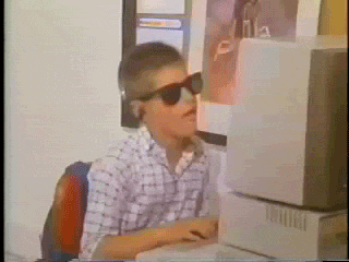 happy, dancing, kid typing on old computer removing sunglasses to reveal another pair 